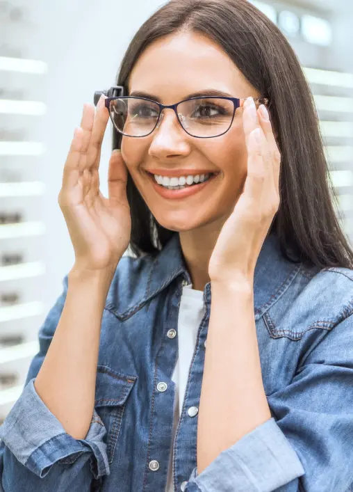 A woman trying on glasses she bought with her vision insurance.