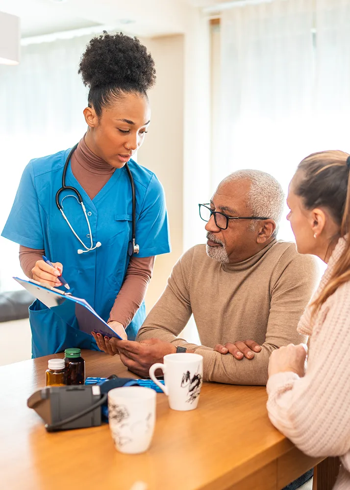 A healthcare professional explaining ancillary benefits insurance to a male patient and his wife.