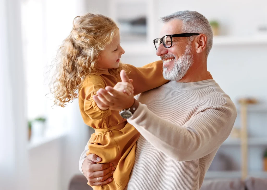 Happy grandfather holding his granddaughter.