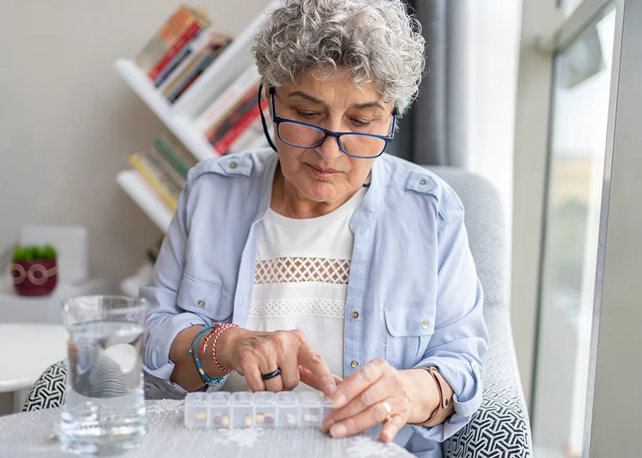 Older woman counting her medicine bought with prescription insurance.