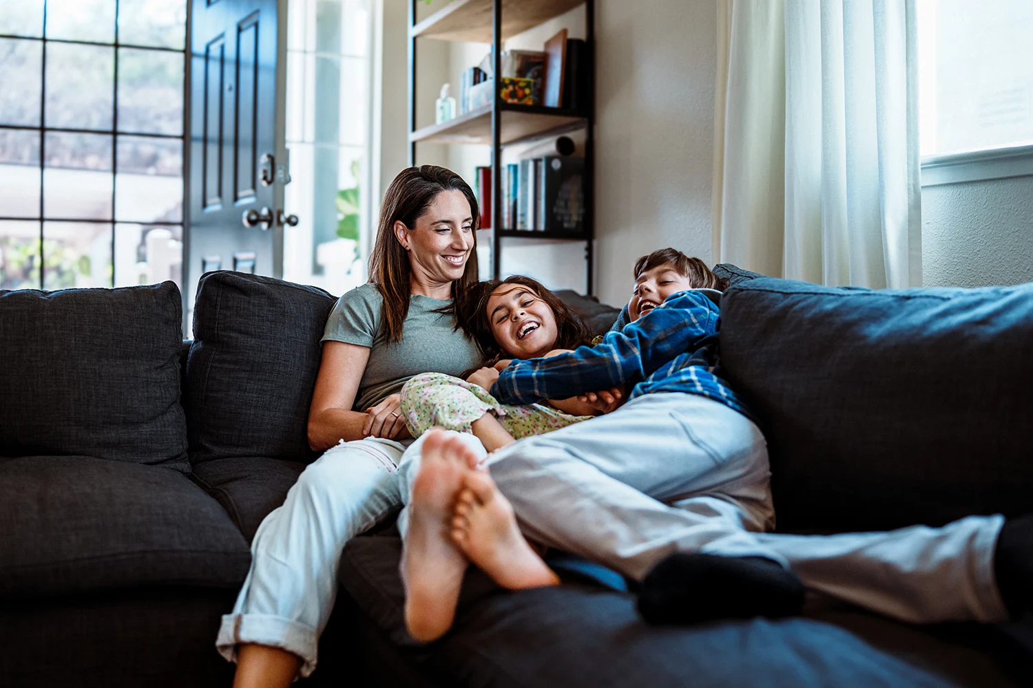 A family together on a couch, not worrying about heath expenses cause they bought supplemental insurance to cover expenses.