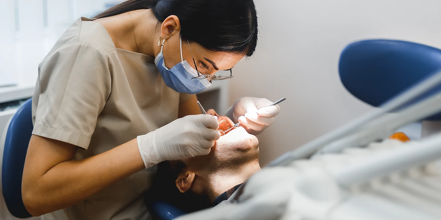 Dentist examining patient in chair