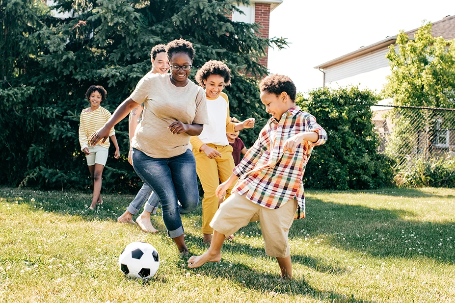 Family playing soccer outside.