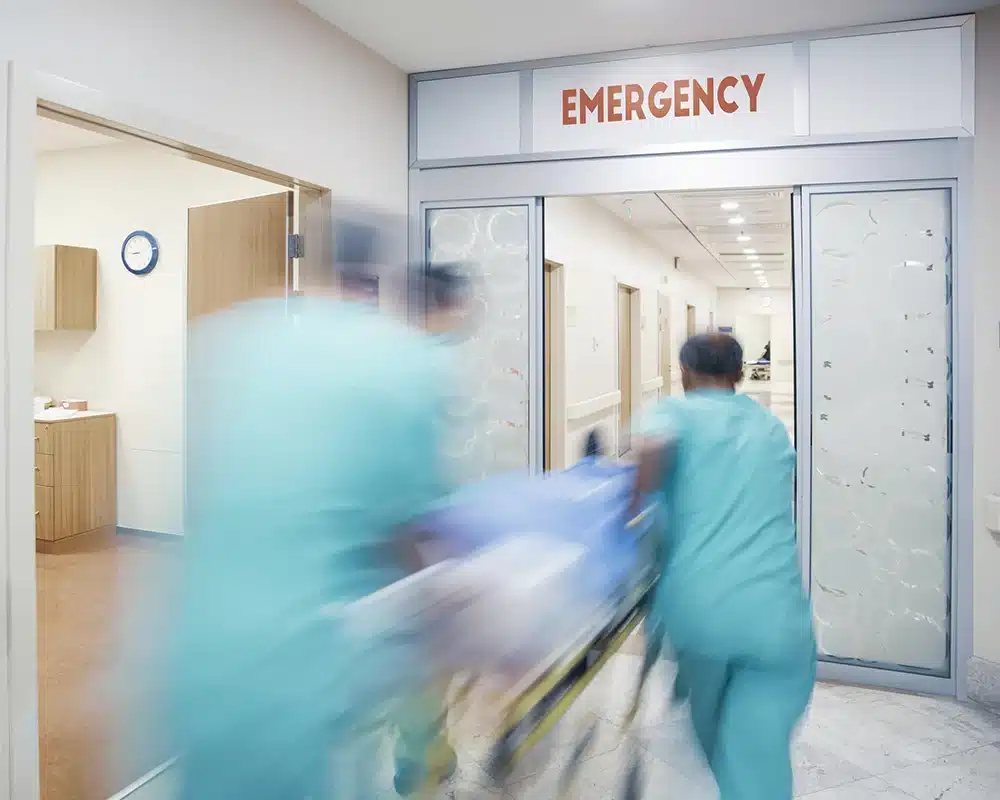 Patient and nursing staff moving through a hospital.